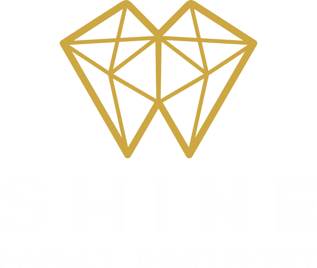 Logo for Shine Family Dentistry featuring a gold geometric diamond above the word “SHINE” in large white capital letters, with “FAMILY DENTISTRY” in smaller white capitals below; transparent background.
